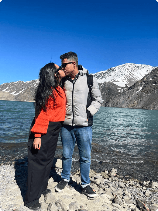 Leandro e Kênnya em uma paisagem com montanhas e lago.